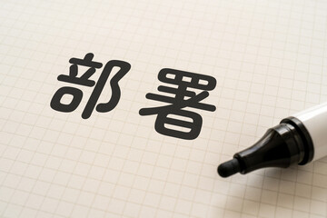 部署と書かれたノートとマーカー