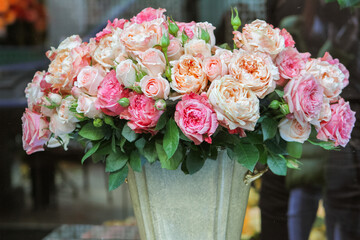 a bouquet of roses in a bucket in a showcase