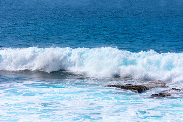 Ocean wave splashing . White waves in blue water 