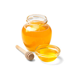 Honey in a jar with a wooden dipper on a white isolated background.