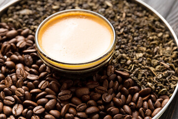 Composition of green tea, coffee beans and coffee in a cup on a dark background close-up.