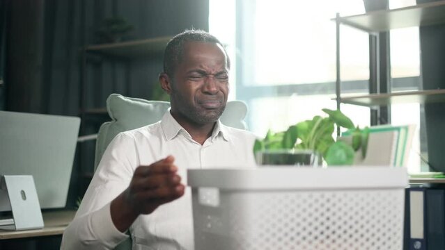 Portrait of fired sad african american businessman carries his box with personal belongings need to leave the office Pensive mature man thinking about future after unemployed looking around indoors