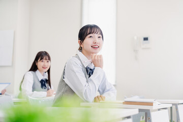 教室でにこやかに授業を受ける女子高生