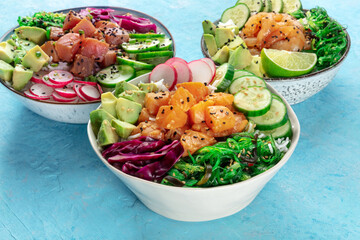 Poke bowl variety. Healthy Hawaiian dish with salmon, tuna, and shrimps, on a blue background