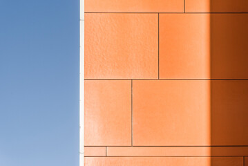 Kolorowy detal na elewacje obiektu, budynku. Materiał z pionowych aluminiowych i pomarańczowych paneli. Nowoczesny budynek