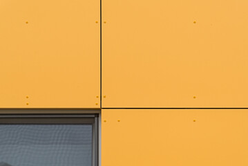 Kolorowa elewacja obiektu, budynku. Materiał z pionowych pomarańczowych paneli.  - obrazy, fototapety, plakaty