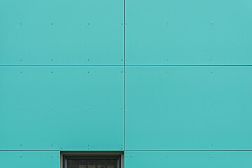 Kolorowa elewacja obiektu, budynku. Materiał z pionowych turkusowych paneli. 