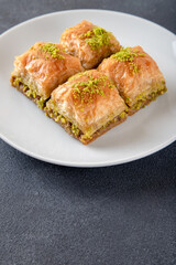 Pistachio Turkish baklava on a white plate.Close-up of four slices of baklava
