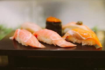 set of sushi and rolls on a wooden plank