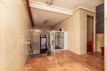 Access portal to a residential building with stairs and tiled floors of brown marble with veins and...