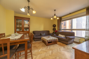 Furnished living room of a conventional home with dark wood furniture and brown armchairs with covers