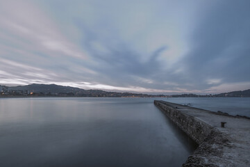 Obraz premium Long exposure image of a breakwater on the Galician coast of Spain at dawn with overcast skies