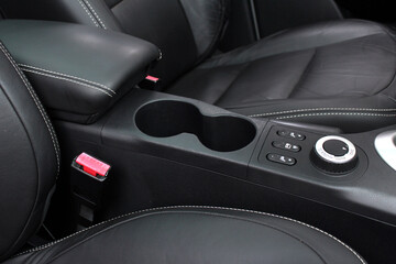 Fototapeta na wymiar Car Leather Seats and Arm Rest. Modern Vehicle Interior Close up. Car cup holder.