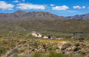 Group Of ATV Riders On A Desert  Dirt Road In Arizona Near The Four Peaks Mountain Range