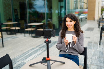 Smiling woman and blogger filming in the coffee shop