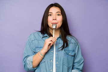 Young woman making eye contact tasting food having cravings