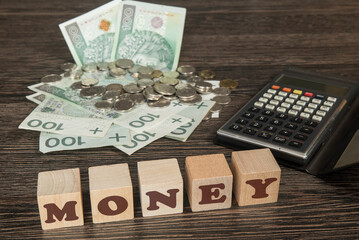 banknoty, bilon wraz z kalkulatorem na stole. Klocki drewniane z napisem MONEY - obrazy, fototapety, plakaty