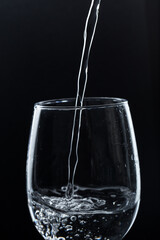 A glass of water on a black background. Close-up