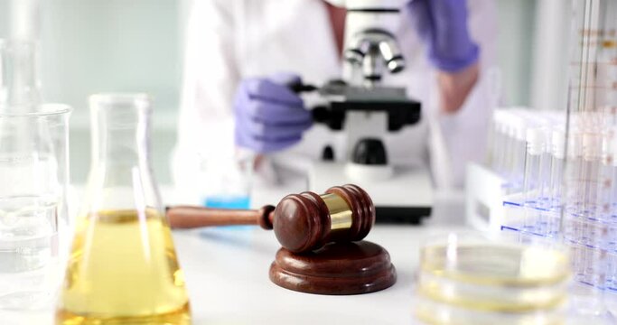 Medical examiner looks through microscope and examines evidence from crime scene in laboratory. Forensic medicine and guide for physicians