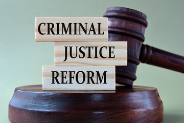 CRIMINAL JUSTICE REFORM - words on wooden blocks against the background of a judge's gavel with a stand.