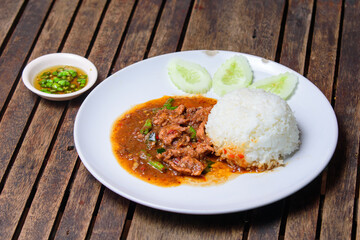 Stir fried beef with holy basil on the white dish.