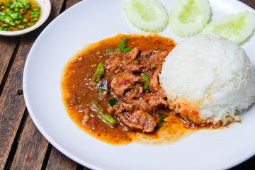 Stir fried beef with holy basil on the white dish.