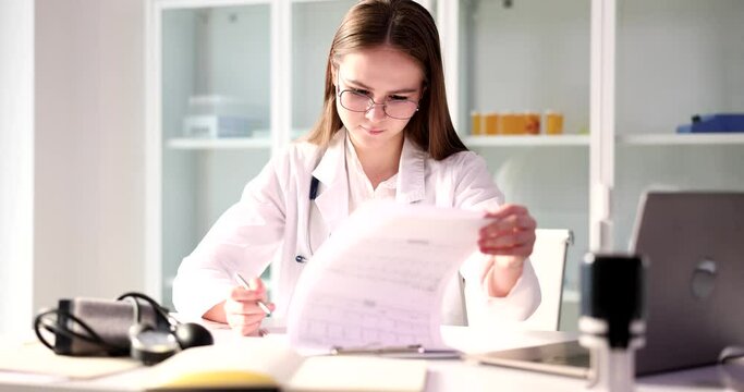 Cardiologist doctor examines cardiogram in clinic closeup. Predicting risk of myocardial infarction