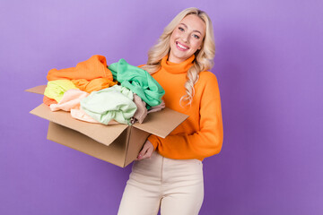 Photo of pretty positive lady hands hold carton box clothes stuff isolated on violet color...