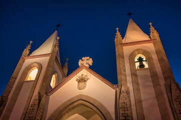 The illuminated facade of the Igreja de Santo Condestável in Lisbon at night, showcasing its...