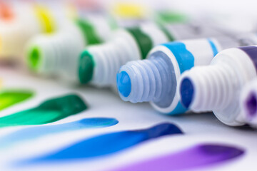 Tubes of paint and close-up of colored brushstrokes. Paints on a white background