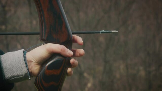 Woman holds a bow and shoots an arrow