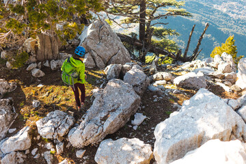 Woman climber with a backpack and a helmet in the mountains. A girl with a backpack walks along a mountain range. adventure and mountaineering concept. mountains of Turkey.