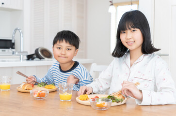 ダイニングで朝食を食べる子供たち