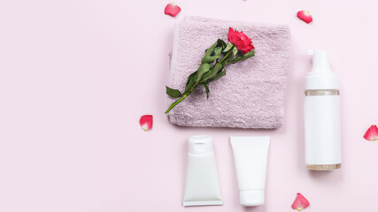 Obraz na płótnie Canvas Composition with skin care products and rose flowers on pink table background. Copy space