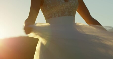 the torso of the bride's dress in the backlight. the bride twirls in the sunset and waves her white dress. close-up