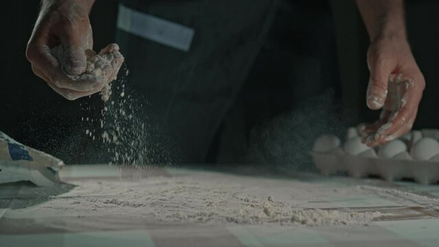 man cooking in the kitchen preparing for baking homemade bread or pastry flour on the table slow motion