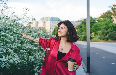Fototapeta premium Happy woman with coffee spending time near bushes