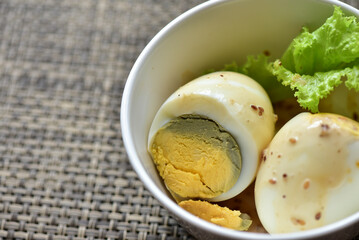 Hard-boiled eggs are placed in a white container with fresh lettuce. Healthy food concept. Increase protein. Weight control.