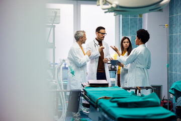Obraz premium A female African-American doctor talking and discussing with her male and female colleagues.