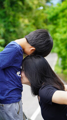 Asian mother kisses son to show affection
