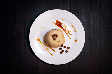 coffee ice cream on white plate with caramel decoration and coffee beans