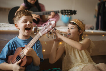 Happy three friends playing on a musical instuments.