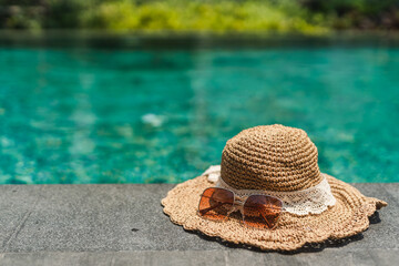 Hat and sunglasses at the side of swimming pool, summer travel concept the side of swimming pool, summer travel concept