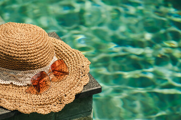 Hat and sunglasses at the side of swimming pool, summer travel concept the side of swimming pool, summer travel concept