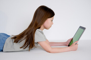 Fototapeta premium Digital tablet with empty screen. Young girl holding tablet in her hands with blank green screen