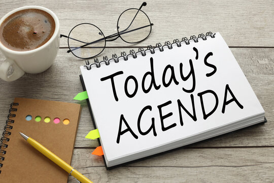 TODAY'S AGENDA text on the notebook with coffee on wooden table