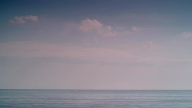 Seascape. Time lapse of white clouds moving over blue sea water. Day time
