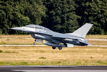 Air force fighter jet plane taking off from an airbase with full speed.
