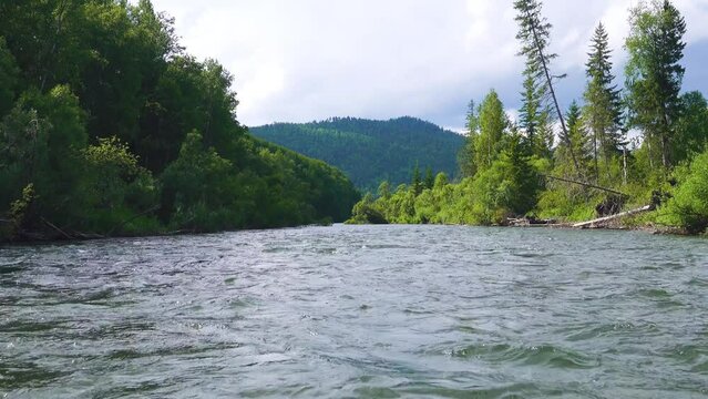 Middle Siberia, Krasnoyarsk Territory. Hilly (coniform hill) river bank, pour. Taiga mixed forests. Low camera position when shooting on water
