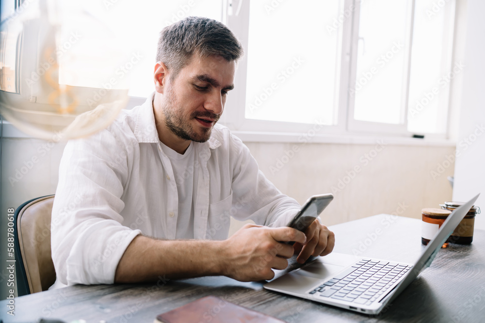 Aufkleber male manager messaging on mobile phone while sitting at table with computer